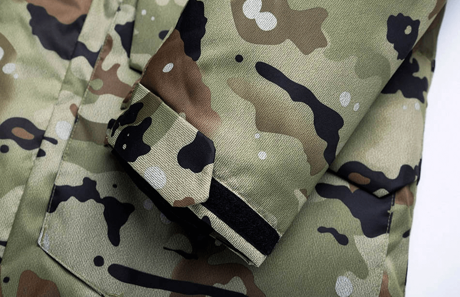 Close-up of camouflage waterproof men's snowboard jacket sleeve with hood, showcasing a high-tech design and durable cotton fabric.